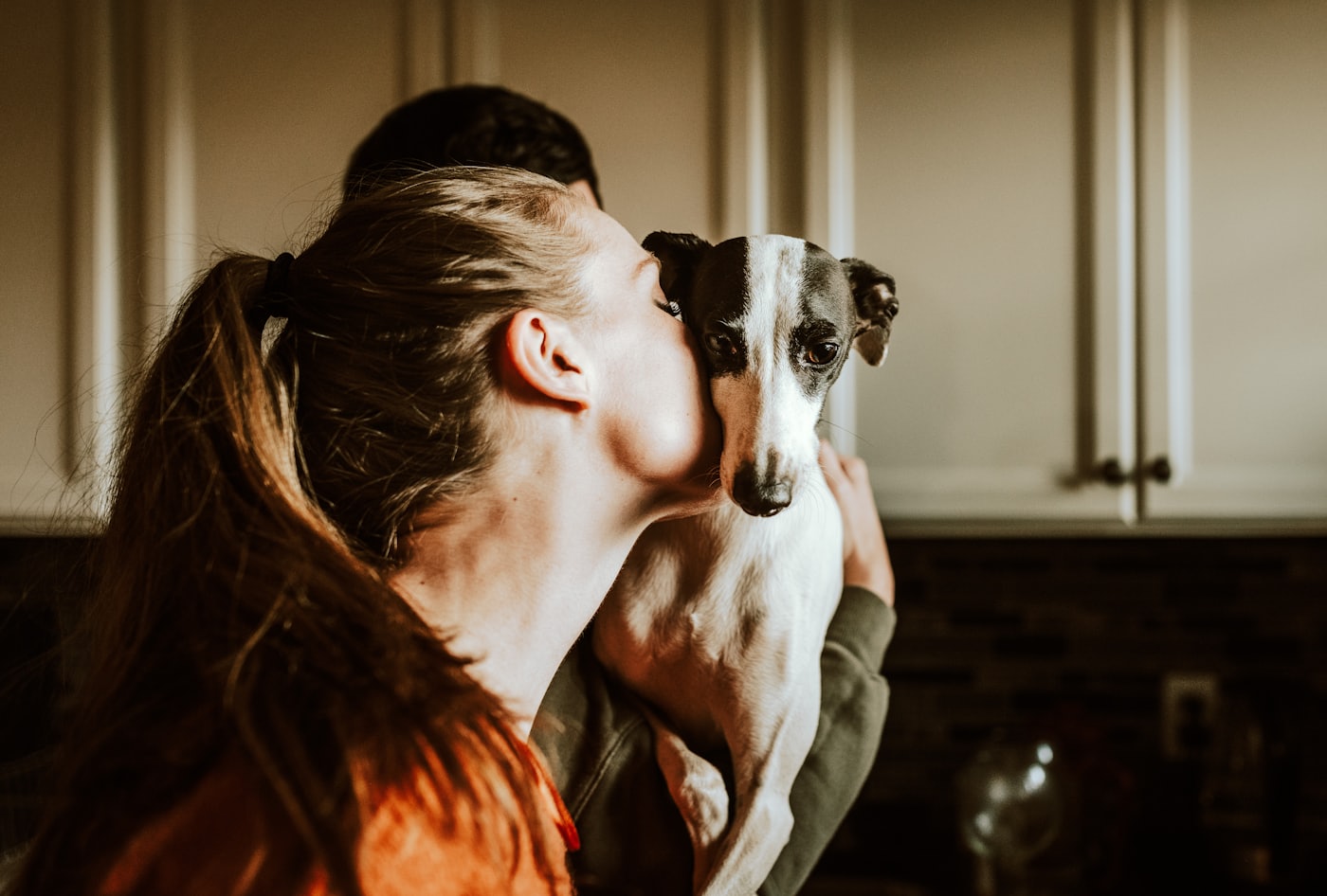 A person resting their forehead against their dog